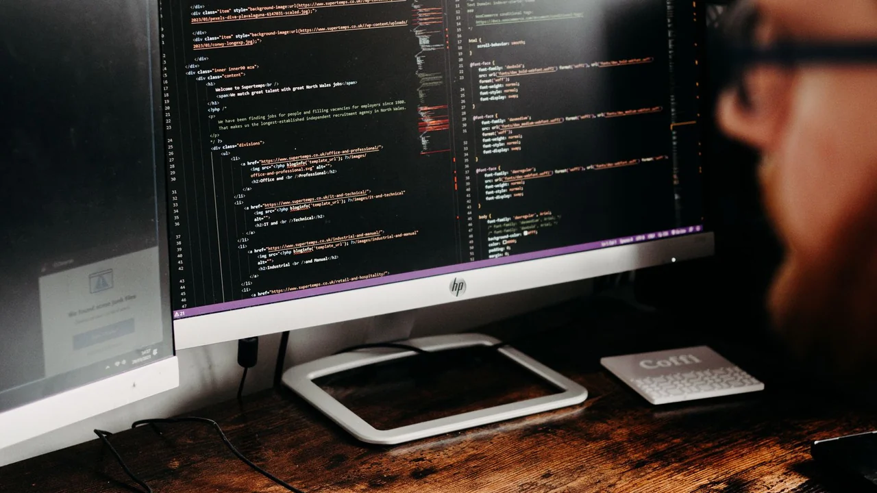 A developer working at a desk with multiple monitors
